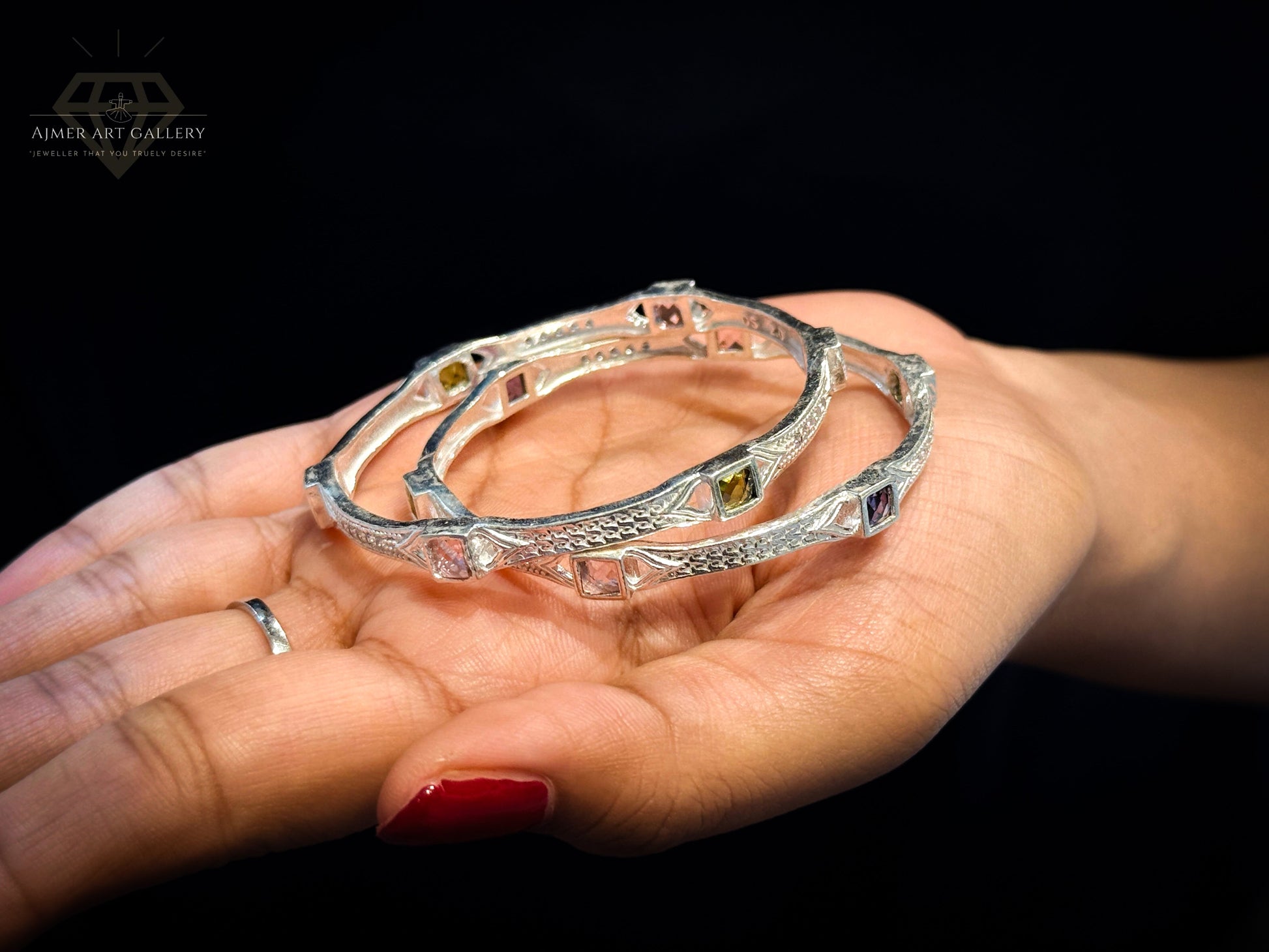 Ajmer Art Gallery baby bangle set in silver with vibrant American Diamond stones held in a hand